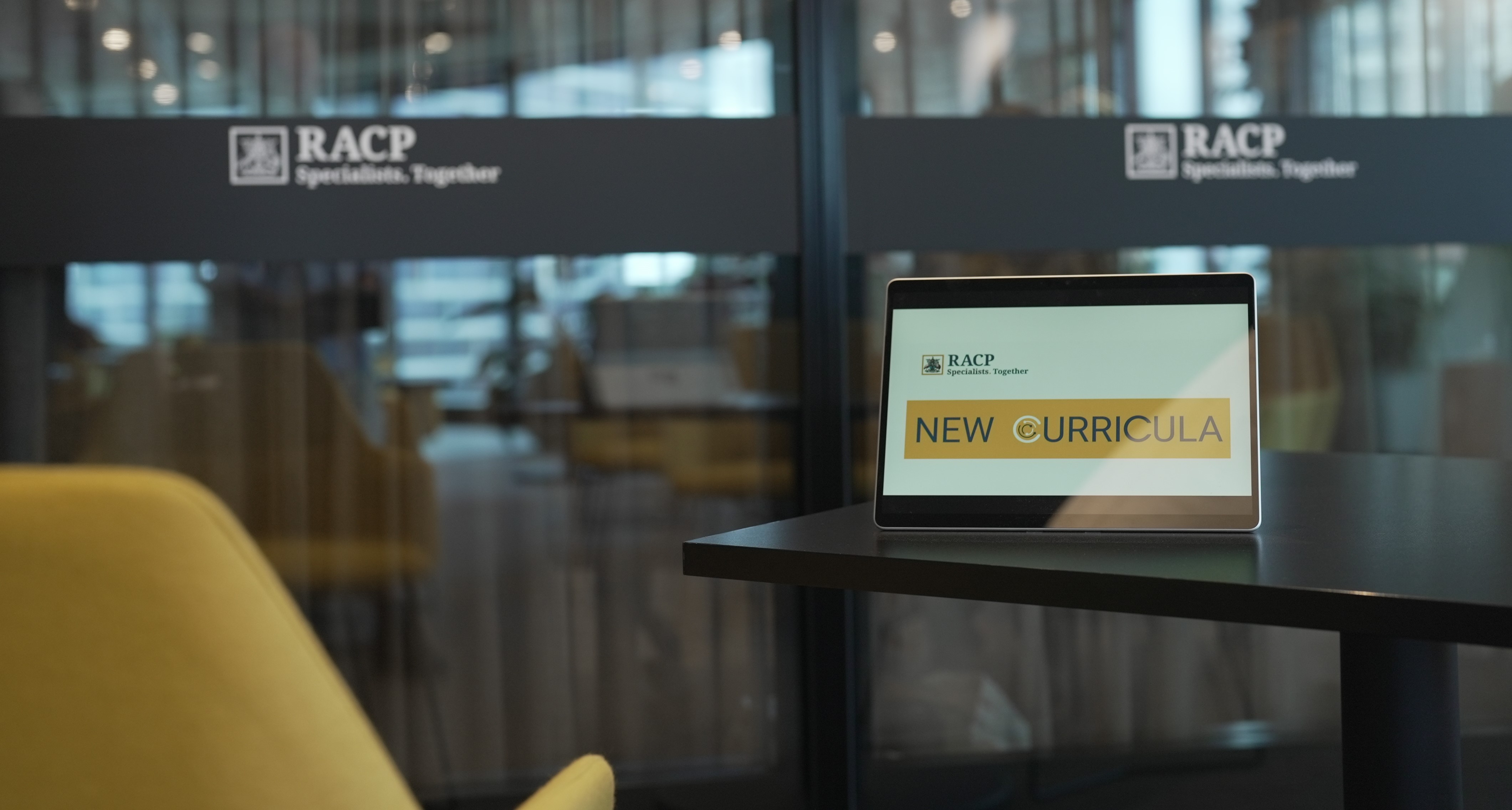 Image of a tablet on a table with a screensaver saying 'curricula renewal'
