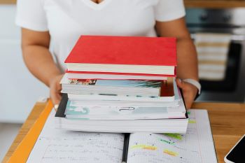woman holding a stack of books