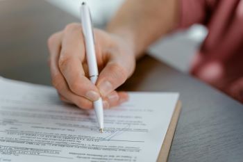 man holding pen and signing document