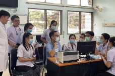 Photo of Dr Ssaysanasongkham working on project with medical staff