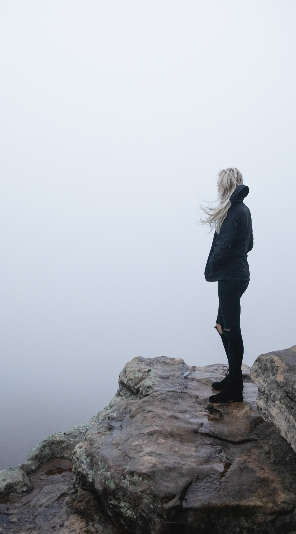 Pensive woman looking out over a cliff
